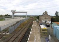 No rural idyll these days. Georgemas Junction now features a mighty 110-tonne gantry crane for road-rail transfer of contaminated materials from the decommissioned Dounreay nuclear site. As seen here on 26th August 2015, the redundant former up platform has been lost to the new facility.<br><br>[David Spaven 26/08/2015]