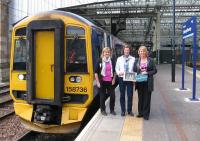 A few minutes prior to the 12.55 return departure from Waverley on 5th September, the three daughters of the late Reverend Brydon Maben (who led the community protest and line blockage at Newcastleton on 5th / 6th January 1969) pose beside the Golden Ticket train with a photo of their father from that fateful night.<br><br>[David Spaven 05/09/2015]