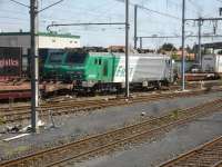 Consecutively numbered SNCF Fret Alstom Prima class 25KV AC electric locos 427029 & 427030 stand on adjacent tracks in Le Boulou east side road to rail transhipment yard in August 2015 attached to empty rakes of Lorry Rail piggyback wagons. A near fully loaded rake stands alongside the far loco.<br><br>[David Pesterfield 05/08/2015]