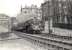 After emerging from the south portal of the tunnel from Crow Road in the summer of 1957, Standard Class 4 2-6-0 76101 has taken the left fork at Partick North Junction with a Maryhill - Rutherglen service. The train will already be slowing for its next stop at Partick West. On the right are the tenements of Maule Drive [see image 52289]. <br><br>[G H Robin collection by courtesy of the Mitchell Library, Glasgow 07/08/1957]