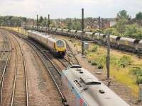 A Cross Country Voyager, running from Penzance to Glasgow, passes a TPE 185, bound for Manchester Airport, just to the south of York station. On the right, a rake of Freightliner coal hoppers has been stabled in the Holgate sidings for the weekend.<br><br>[Mark Bartlett 18/07/2015]
