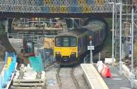 A Manchester Victoria to Blackpool North service exits the Down tunnel at Farnworth and approaches the station on 31 October 2015. On the right the platform edge has been moved over to suit the new track alignment when both tracks run through the rebored and enlarged Up tunnel. On the left below the rebuilt Cemetery Road bridge is the tunnel boring machine which is currently being dismantled.<br><br>[John McIntyre 31/10/2015]