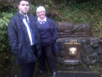 Station staff members Barry Limbert and Elaine Phillips with the restored Hood's Well at Port Glasgow Station. The public fountain dates from 1843 when James Hood, the first stationmaster at Port Glasgow (opened 1841), retired - this being his choice of retirement gift. The well was re-discovered during vegetation clearance in 2001.<br><br>[John Yellowlees 06/11/2015]