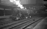 The north end of a cold and wet Carlisle platform 4 on 23 January 1965 sees Crewe North's Britannia Pacific no 70051 <I>Firth of Forth</I> waiting patiently for the road to Upperby shed, having recently arrived on the other side of the station with a terminating parcels train from the south.<br><br>[K A Gray 23/01/1965]