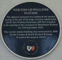 A blue plaque explains the replica memorial that is fixed inside the station building at Newton-le-Willows relating to the first railway fatality.<br><br>[John McIntyre 09/10/2015]