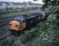 37085 and a fellow Eastfield based 37 draw a long oil train out of Bishopbriggs Oil Depot in 1987. [See image 53783] for the same view in 1971.<br><br>[Ewan Crawford 27/05/1987]