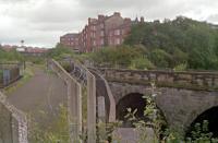 1988 view from the girder bridge of the Dumbarton - Balornock line showing the stone arch viaduct of the line from Glasgow Central Low Level with the junction in the left background. [See image 10342].<br><br>[Ewan Crawford //1988]