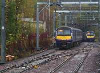 Having just cleared the newly installed crossover which is part of the Anniesland EGIP Works, EMU 320312 heading for Milngavie is just about to pass 320306 bound for Edinburgh on a rainy 10th November 2015.<br><br>[Colin McDonald 10/11/2015]