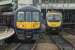 Units at Piccadilly - 319368 calls at platform 13 with a Liverpool Lime Street to Manchester Airport Northern Electrics service. On the right 185150 enters the main station with a TPE service that is also heading to the Airport but will reverse first.<br><br>[John McIntyre 10/12/2015]