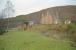 The Mound seen from the trackbed of the Dornoch Light Railway in 1998. The station platform can be seen in the distant left. The 'mainline' is beyond the station building seen to the right. Base of water tank to the right of the branch trackbed.<br><br>[Ewan Crawford //1998]