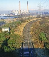 A March 1987 view west from the original Kincardine road bridge showing the town’s two former stations, the rail version in the foreground and the power variety in the background.  At the time, this part of the line had fallen into disuse, but it became more active 10 years later for first coal and then rail engineering traffic after the power station had been closed down and demolished. From 2008 until 2016 it carried considerable coal traffic round the clock for the nearby Longannet power station after the line through Alloa reopened.  <br><br>[Mark Dufton /03/1987]