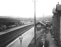 View east over New Galloway station sometime in the late 1920s looking towards Castle Douglas. Note the LMS and NB markings still present on the wagons in the goods yard over on the left. The station house survives to this day, albeit much modified [see image 29120]. [Old family photograph]. <br><br>[John Furnevel Collection //]