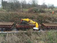 Road rail excavator working on diggings for new trackside drainage. OHLE mast surveyor setting out on the embankment behind.<br><br>[Martin MacGuire 02/04/2016]