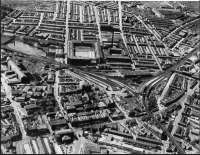 An aerial image of Accrington station looking west, probably taken in the 1950s. It clearly shows the triangular layout that was in place until 1966 when the line to Stubbins and Bury closed. The south to west chord had no platforms but passed by the goods shed. The surviving Burnley to Blackburn line runs from the bottom right hand corner through the station to the middle right of the picture - everything else has gone. <I>Photographer unknown</I>.<br><br>[Mark Bartlett Collection //]