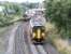 A pair of ScotRail class 156 DMUs passing just north of Dumfries station on 30 July 2004. A Stranraer Harbour – Newcastle service is about to call at the station, while the northbound train has just restarted its journey from Carlisle to Glasgow Central and is about to pass below the bridge carrying the A701.<br><br>[John Furnevel 30/07/2004]