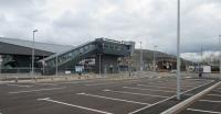 Port Talbot station is almost complete with new car parking and facilities. This is a view of the down platform side with level crossing (which is now pedestrian only) and signal box in the background. The 1248 to Paddington is pulling out the station.<br><br>[Alastair McLellan 15/04/2016]