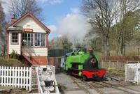 0-6-2ST <I>Barber</I> runs past the signal box at Alston in May 2016 as it draws forward to couple on to its train after running round. It seems to be semi-permanently coupled to a four wheel hopper wagon, emblazoned with <I>GAS</I>. This may be just in homage to the loco's working life at Harrogate Gas Works, but it may also be a nice solution to the problem of where to put the air brake compressor for the STR coaches.<br><br>[Mark Bartlett 02/05/2016]