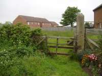 An old crossing gate on the north side of Browns Terrace, Hinderwell, complete with intact latching mechanism on the closing post. View along the trackbed towards next station at Staithes some 3Km beyond. [See image 55498] for a view of the gate from the other side over 25 years earlier. <br><br>[David Pesterfield 29/05/2016]