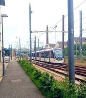 A westbound tram shortly after leaving Haymarket heading for its next stop at Murrayfield Stadium on 4 July 2016. The road on the left is Haymarket Yards, site of the former goods and coal depots, while on the right beyond the fence is the E&G main line. Haymarket station stands in the background.<br><br>[Andy Furnevel 04/07/2016]