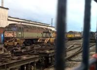Another class 47/4 seen through the gates of Nemesis Rail at Burton-upon-Trent, along with a backhoe loader and an industrial shunter (just visible on the right).<br><br>[Ken Strachan 09/07/2016]