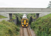 158715, on a Wick to Inverness service, has just passed through the closed station at Meikle Ferry and is seen under the approach road for the Dornoch Firth bridge. 20th July 2016<br><br>[Mark Bartlett 20/07/2016]