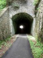The first time a Railscot contributor (Colin Harkins, [see image 10790]) photographed this tunnel, 1 mile east of Peebles, it was spooky and neglected. Since then a cycle and walkway has been built through it and now it's just spooky. This is the east portal, complete with (almost whole) telegraph insulators. This short tunnel took the line under the A72.<br><br>[David Panton 05/07/2016]
