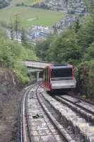 View from a descending car of its counterpart at the passing loop of the Harder Kulm Funicular. This climbs steeply from adjacent to Interlaken Ost station, the canopies of which are visible top left in this picture. [See image 56012] for the view of Interlaken West from the top station.   <br><br>[Mark Bartlett 19/06/2016]