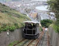 Funicular cars crossing at the mid-point of the Aberystwyth Cliff Railway in September 2016, with the bay and promenade visible behind. The change in gradient for the final stretch down to the lower station is very noticeable. <br><br>[Mark Bartlett 18/09/2016]