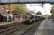 Watched by two potential enthusiasts, EMU 333013 pulls away from Burley-in-Wharfedale on an Ilkley to Leeds service on 21st October 2016. Once the junction for the Otley (and Harrogate) line the station buildings here have been removed and only basic platform shelters are available for passengers but there are frequent trains to Leeds and Bradford.<br><br>[Mark Bartlett 21/10/2016]