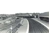 Looking north over the goods yard and west side platforms 1 and 2 at Kilwinning station on Saturday 4 July 1959. In the background an Edinburgh Princes Street - Ayr train is about to call at platform 4. The train is hauled by Dalry Road shed's Black 5 no 44994. <br><br>[G H Robin collection by courtesy of the Mitchell Library, Glasgow 04/07/1959]
