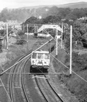 An Airdrie via Singer AM3 'Blue Train' departs from Cardross in March 1974. The east end of the station can be seen beneath the footbridge in the middle distance.<br><br>[John McIntyre /03/1974]