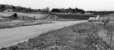 The road in front is the A95 at Gaich looking towards Grantown-on-Spey. Across the road in the middle distance is the trackbed of the railway as it approaches Grantown-on-Spey West. A few feet below me is the tackbed which was severed when the road was re-aligned in the mid 70s and today remains a hurdle for the Strathspey Railway's ambition to reach the town.<br><br>[John McIntyre /04/1977]