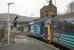37419 <I>Carl Havilland</I> pulls away from the Carnforth stop with 2C47 Preston to Barrow-in-Furness on 20th March 2017 - as a slim video camera emerges from between the window bars to record the departure. DRS are contracted to provide the 2x37 hauled sets for Northern Cumbrian Coast services until January 2019. <br><br>[Mark Bartlett 20/03/2017]