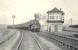 Standard Mogul 77015 at Byrehill Junction on 4 April 1959 with an Ardrossan - Kilmarnock train.   <br><br>[G H Robin collection by courtesy of the Mitchell Library, Glasgow 04/04/1959]