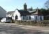 <I>'At the end of the station approach road the single storey former gate lodge also still stands, again probably by Tite...'</i> [Britain's Historic Railway Buildings - Gordon Biddle]. Looking south west across the main road through the village on 27 March 2017, just beyond the building the Beattock station approach road runs off to the right.<br><br>[John Furnevel 27/03/2017]