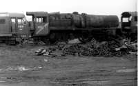 45699 <I>Galatea</I> looking very woebegone in Barry scrapyard in 1975. Compared with Bill Jamieson's picture five years earlier the centre driving wheels have been cut through and the chimney has disappeared. The loco left the yard in 1980 to Tyseley, originally as a source of spares, but in 2002 went to West Coast Railways - and the rest is preservation history [See image 47860]. The NBL Type 2 buffered up to 45699 is widely reported as D6122, but one cab displayed D6121 as seen here leading to disputes about identity. <br><br>[Mark Bartlett 28/10/1975]
