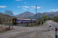 An Oban to Glasgow service heads east over Inverhaggernie Level Crossing No 1, west of Crianlarich. The rear of the train is by the camera.<br><br>[Ewan Crawford 05/05/2017]