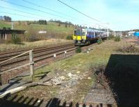 The remains of Beattock station looking north through the Network Rail access gate on 27 March 2017. The approaching train is the 0906 First TransPennine Express Glasgow Central - Manchester Airport.<br><br>[John Furnevel 27/03/2017]