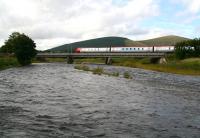 A dark and dangerous looking River Clyde at Lamington, photographed during the early evening on 1 September 2006. In the background a Virgin Voyager crosses the viaduct southbound, heading for Birmingham New Street.<br><br>[John Furnevel 01/09/2006]