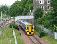 A mid-morning Tweedbank - Edinburgh service runs north under the footbridge linking High and Low Buckholmside  shortly after leaving Galashiels station on 16 June 2017.<br><br>[John Furnevel 16/06/2017]
