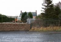 Site of Pomathorn level crossing - looking back towards the old station in December 2005 with the crossing gates now replaced by a wire mesh fence. The sizeable goods yard stood beyond the station house. Pomathorn Mill dominates the left background.<br><br>[John Furnevel 11/12/2005]
