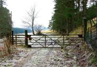 Original gate at the entrance to the railhead at Victoria Lodge in February 2006, looking north along the trackbed. The wooden railings to the left have replaced the former metal pedestrian gate although the original gatepost remains.<br><br>[John Furnevel 01/02/2006]