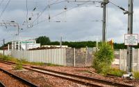 An access break in the fence separating the Millerhill freight lines and the site of the new electric train depot, photographed on  13 July 2017 looking north towards Newcraighall station. Behind the fence is residual rubble from the demolition of the former MPD  and, beyond that, the framework of the new train washing plant together with various new buildings under construction. The sign would be worth preserving!<br><br>[John Furnevel 13/07/2017]
