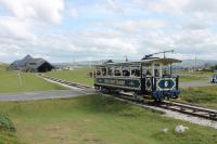 A descending Great Orme tramcar nearing the winding house at Halfway on 26th July 2017. Because the cars on the upper level are hauled from Halfway they are fastened to a continuous loop cable rather than just <I>hanging</I> from it as on the lower section. They also operate on a reserved track and so don't need protective side guards.<br><br>[Mark Bartlett 26/07/2017]