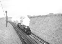 Stanier Black 5 4-6-0 no 44767 with the much photographed northbound train of diesel shunters over the Waverley route on 11 April 1967, seen here approaching Kelso Junction. This unique locomotive (fitted with Stephenson valve gear) was subsequently preserved [see image 4874] and now carries the name <I>George Stephenson</I>.<br><br>[Bruce McCartney 11/04/1967]