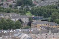 Seen across the Dumbarton rooftops, from the ramparts of the Castle, a Class 320 EMU pauses at the East station on its way to Balloch. 3rd August 2017. <br><br>[Mark Bartlett 03/08/2017]
