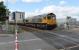 GBRf 66710 <I>Phil Packer BRIT</I> takes a Blyth to Doncaster train of bogie hoppers through Hartlepool station and over the level crossing on 24th June 2017. The train is on the Up Line, which is effectively freight only at this point as the old Up Platform is disused and southbound passenger trains cross to the Down Line to call at the station. <br><br>[Mark Bartlett 24/06/2017]