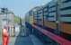 A reminder of when the Stranraer line carried freight - not so long ago, 1989. Here a northbound train of steel sections passes Dunragit level crossing and the token exchange has just taken place. There was a safety man with a flag and the signal man had the luxury of a colleague who swapped the tokens while he remained in the box with the levers.<br><br>[Ewan Crawford //1989]