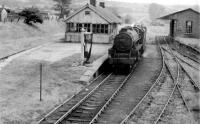 Black 5 45070 enters Garstang Town station on 13th August 1959 with a single brakevan. Taken nearly thirty years after passenger services finished, this photo clearly shows the very unusual signal box at Garstang, which was on the island platform but at right angles to the tracks. The signal box was wider than the main station building, although it shared the roof profile, allowing a view to the east for the signalman. <br><br>[Knott End Collection 13/08/1959]