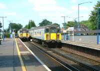 Trains passing over Lymington Road level crossing at the north end of Brockenhurst station in July 2002.<br><br>[Ian Dinmore 26/07/2002]